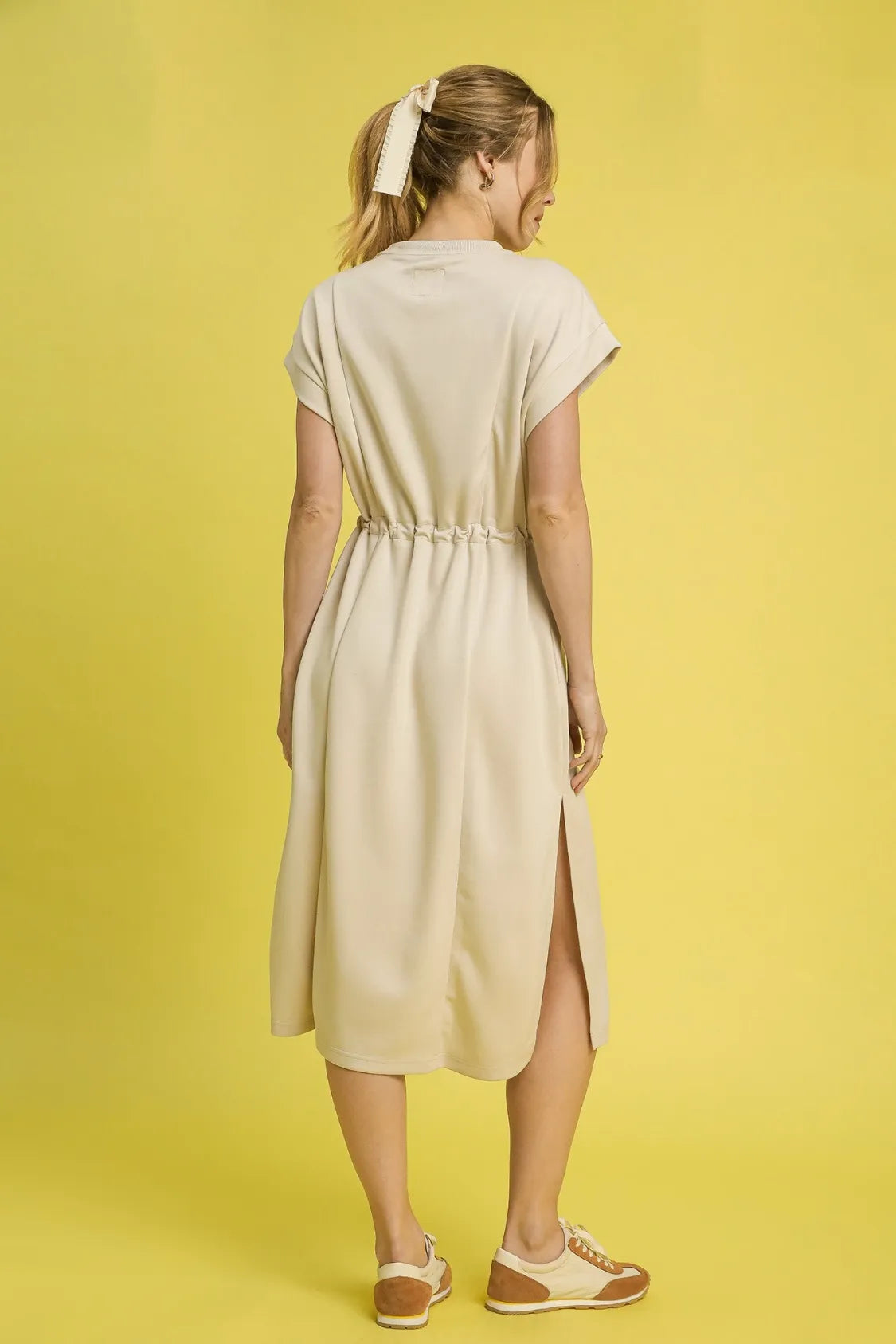 This versatile midi tee dress features a relaxed, comfortable fit perfect for everyday casual wear. Crafted from soft cotton blend fabric in a neutral beige tone, it offers effortless style with its crew neckline and short sleeves.