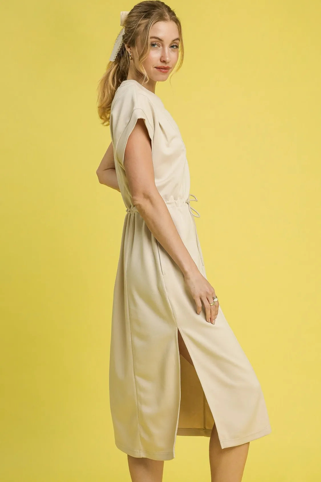 This versatile midi tee dress features a relaxed, comfortable fit perfect for everyday casual wear. Crafted from soft cotton blend fabric in a neutral beige tone, it offers effortless style with its crew neckline and short sleeves.