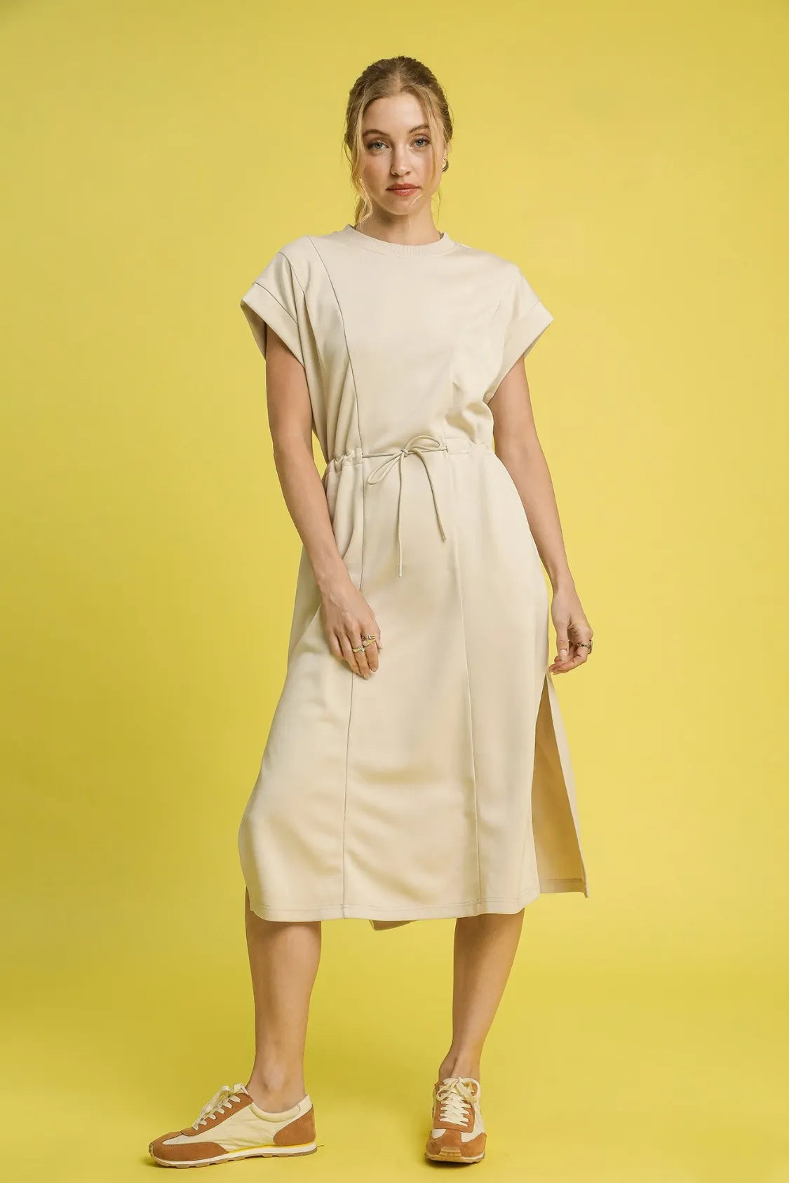 This versatile midi tee dress features a relaxed, comfortable fit perfect for everyday casual wear. Crafted from soft cotton blend fabric in a neutral beige tone, it offers effortless style with its crew neckline and short sleeves.